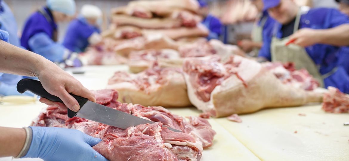 Cutting meat in slaughterhouse .