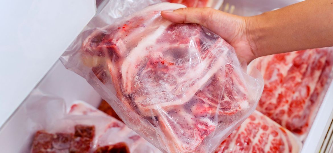 Hand choosing fresh raw ribs meat in freezer